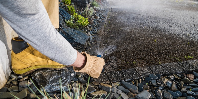 Landscaper checking sprinkler heads