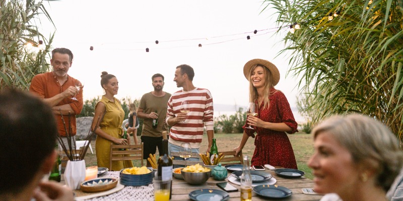 Group of friends spending time in the yard - 5 Tips to Plan the Best Outdoor Summer Party at Your Estate (Infographic)